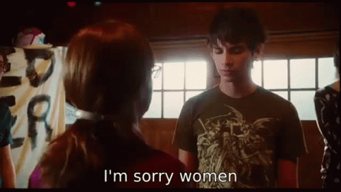 A Man And Woman Are Standing Next To Each Other And The Woman Is Saying I 'M Sorry Women . GIF