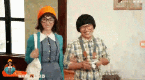 A Man And Woman Are Standing Next To Each Other In A Room . GIF
