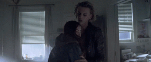 A Man And Woman Hugging In A Dark Room GIF