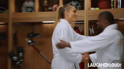 A Man And Woman Hugging In A Locker Room With Laugh Out Loud Written On The Bottom Right GIF