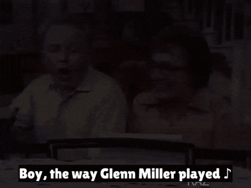 Man And Woman Sitting At Table With Glenn Miller Text GIF