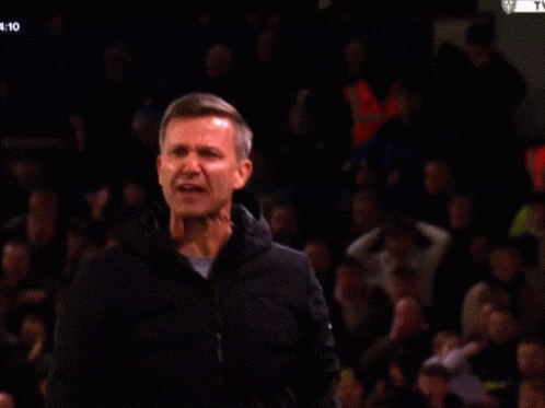 a man applauds in front of a crowd with the time 4:11