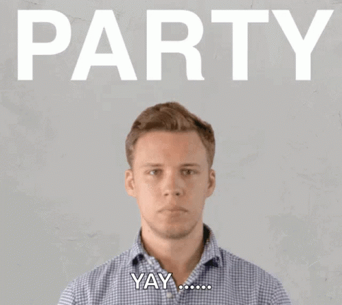 A Man Blowing Confetti In Front Of A Sign That Says Party GIF