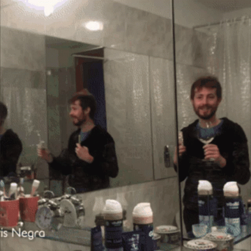 A Man Brushing His Teeth In Front Of A Mirror With The Word Negra On The Bottom Left GIF