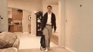 A Man Carrying A Backpack Is Walking Through A Living Room GIF