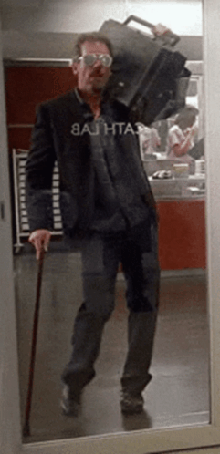 A Man Carrying A Suitcase Has A Shirt That Says 8Ajhta3 GIF