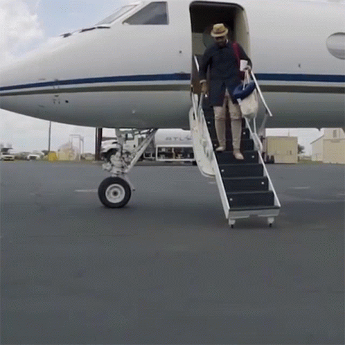 A Man Climbs The Stairs Of An Airplane That Says Atl GIF