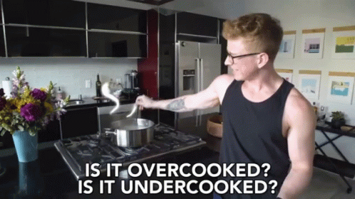 A Man Cooking In A Kitchen With The Words " Is It Overcooked Is It Undercooked " Above Him GIF