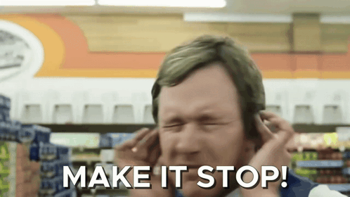 A Man Covering His Ears In A Store With The Words Make It Stop Written Below Him GIF
