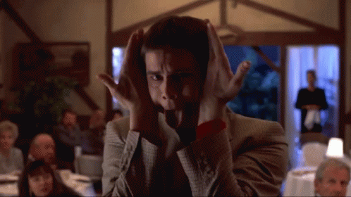 A Man Covering His Ears With His Hands In Front Of A Crowd GIF