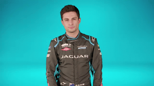 A Man Covering His Face With A Black And White Checkered Flag With The Letter S On It GIF