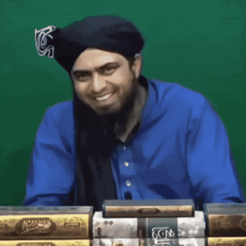 A Man Covering His Face With His Hand In Front Of A Stack Of Books GIF