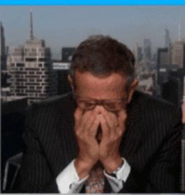 A Man Covering His Face With His Hands In Front Of A City Skyline GIF