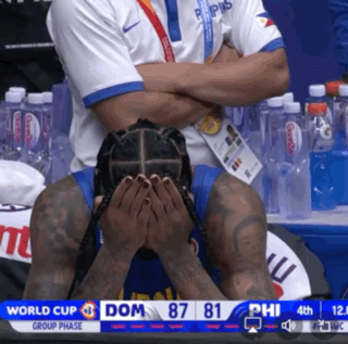 A Man Covering His Face With His Hands While Watching A Basketball Game In The World Cup Group Phase GIF