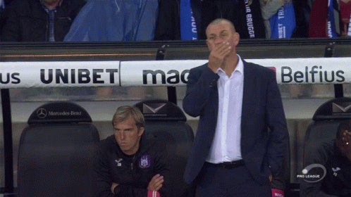 A Man Covering His Mouth In Front Of A Mercedes Benz Sign GIF