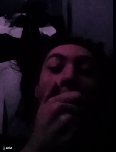 a man covering his mouth with his hand in a dark room with a nokia logo on the bottom right
