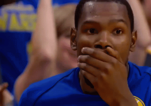 A Man Covering His Mouth With His Hand While Wearing A Golden State Warriors Jersey GIF