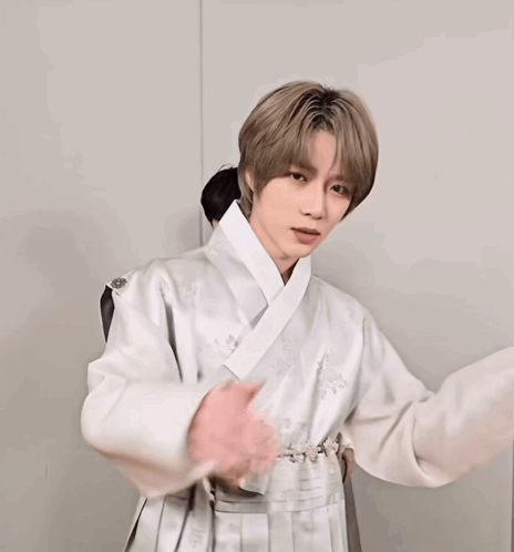 A Man Covering His Mouth With His Hands And Wearing A White Jacket GIF