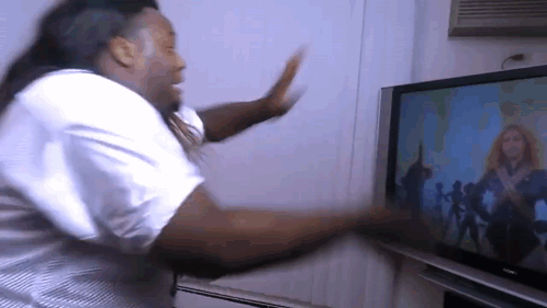 A Man Dancing In Front Of A Sony Television GIF