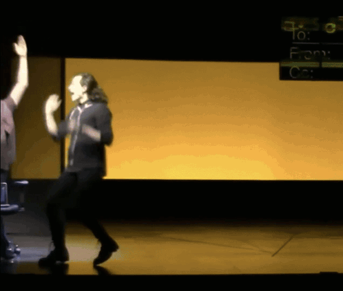 a man dancing on a stage in front of a screen that says " to : from "