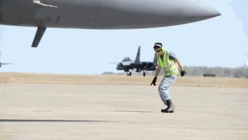 A Man Doing A Handstand In Front Of A Plane GIF