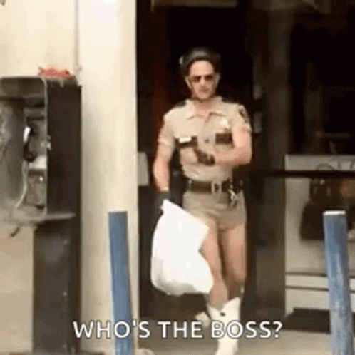 a man dressed as a police officer is carrying a bag and asking who 's the boss .