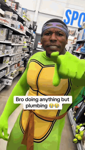 A Man Dressed As A Teenage Mutant Ninja Turtle Is Pointing At The Camera GIF