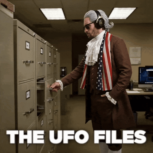 A Man Dressed As Benjamin Franklin Pulls A Drawer Out Of A Filing Cabinet GIF