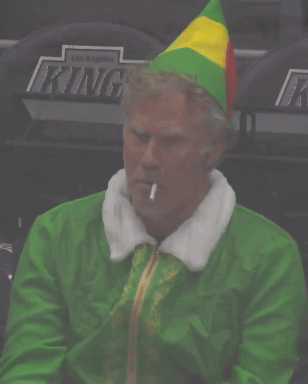 A Man Dressed As Buddy The Elf Smoking A Cigarette In A Stadium GIF