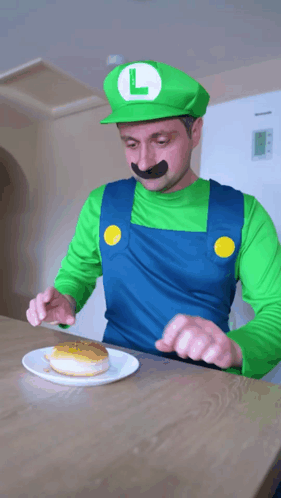 A Man Dressed As Luigi From Super Mario Is Eating A Donut GIF