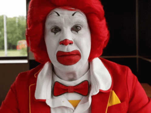 A Man Dressed As Mcdonald 'S Clown With Red Hair And White Face Paint GIF