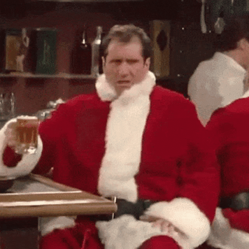 Santa Sitting At Table With Beer GIF