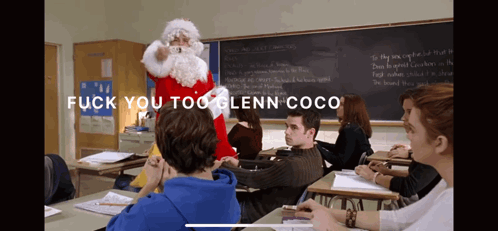 A Man Dressed As Santa Claus Stands In Front Of A Classroom With The Words " Fuck You Too Glenn Coco " On The Bottom GIF