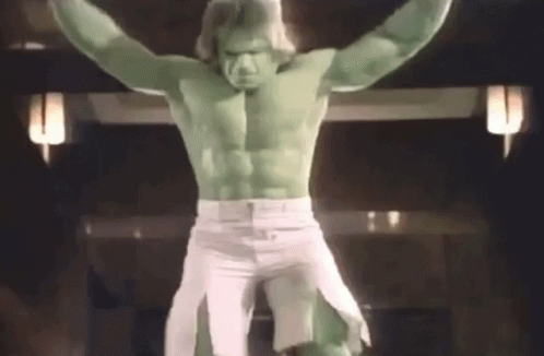 A Man Dressed As The Hulk Is Standing On A Cross With His Arms Outstretched GIF