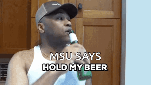 A Man Drinking A Beer With The Words Msu Says Hold My Beer Below Him GIF