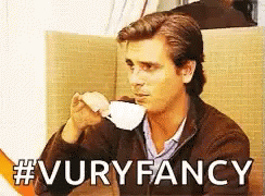 A Man Drinking A Cup Of Coffee With The Words #Vuryfancy Written Below Him GIF