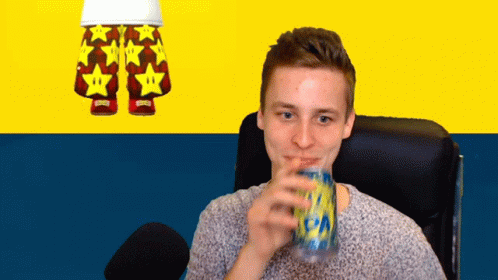 A Man Drinking From A Can With A Pair Of Shorts With Stars On Them In The Background GIF