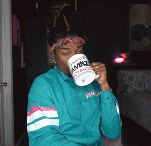 A Man Drinking From A Mug That Says Amnz On It GIF