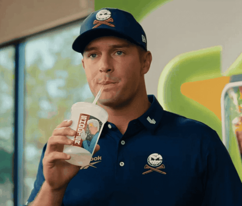 A Man Drinking Through A Straw From A Cup That Says " Snickers " On It GIF
