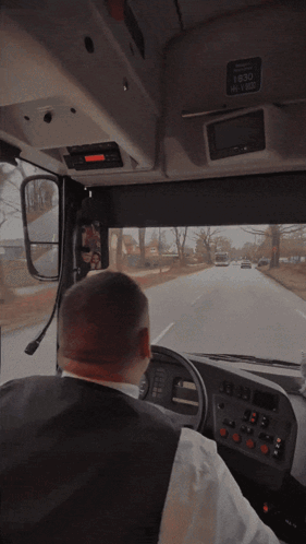 A Man Driving A Bus With The Time 1630 On The Top Of The Dashboard GIF