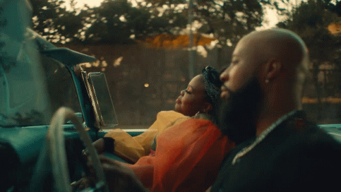 A Man Driving A Car With A Woman Sitting In The Back Seat GIF