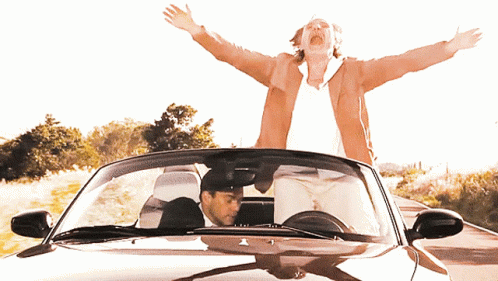 a man driving a car with his arms outstretched