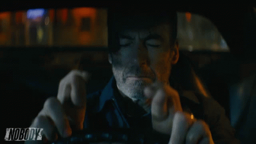 a man driving a car with the word nobody on the bottom