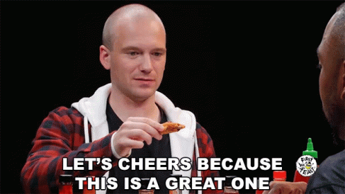 A Man Eating A Chicken Wing With The Words Let 'S Cheers Because This Is A Great One Above Him GIF
