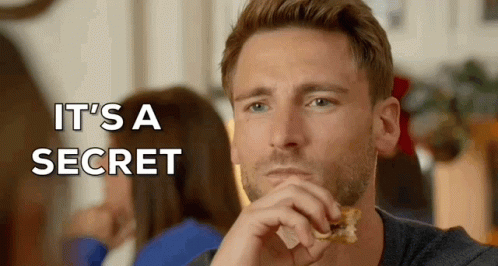 A Man Eating A Piece Of Food With The Words " It 'S A Secret " Written Above Him GIF
