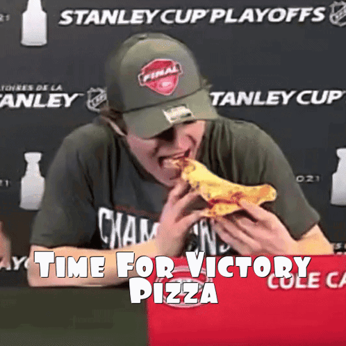 a man eating a slice of pizza in front of a stanley cup playoffs banner