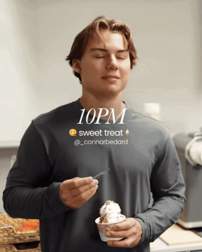 A Man Eating An Ice Cream Cone With A 10Pm Sweet Treat Advertisement Behind Him GIF