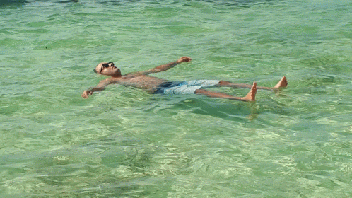 A Man Floating On His Back In The Water GIF