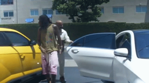 A Man Getting Out Of A White Car With A Yellow Car Behind Him GIF
