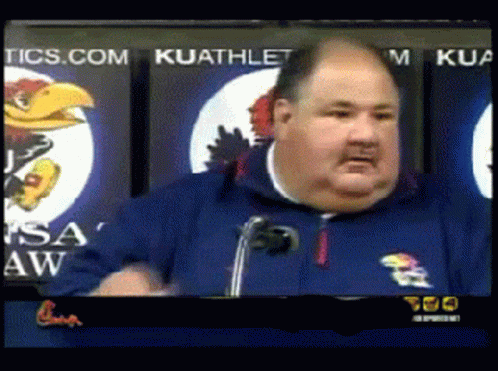 A Man Giving A Speech In Front Of A Kuathletic Sign GIF